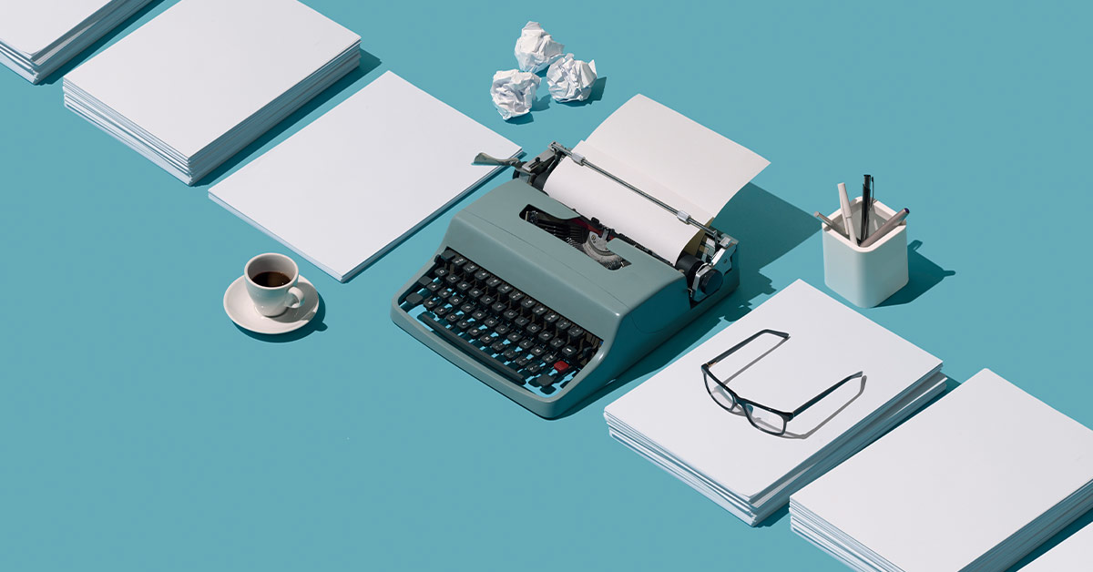 Image of vintage typewriter header and blank sheets of paper.